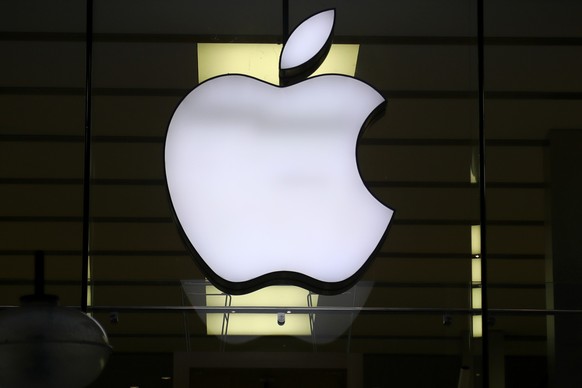 FILE - The logo of Apple is illuminated at a store in the city center in Munich, Germany, Wednesday, Dec. 16, 2020. Apple’s profit slipped during the past quarter of 2022, but the world’s largest tech ...