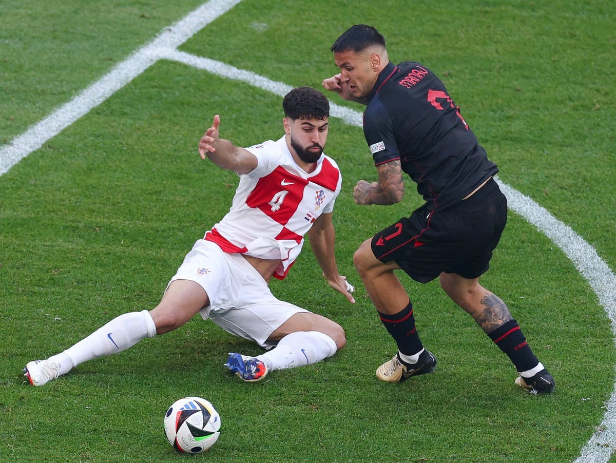 19.06.2024, Hamburg: Fu�ball, UEFA Euro 2024, EM, Kroatien - Albanien, Vorrunde, Gruppe B, Spieltag 2, Volksparkstadion Hamburg, Kroatiens Josko Gvardiol (l) und Albaniens Rey Manaj k�mpfen um den Bal ...