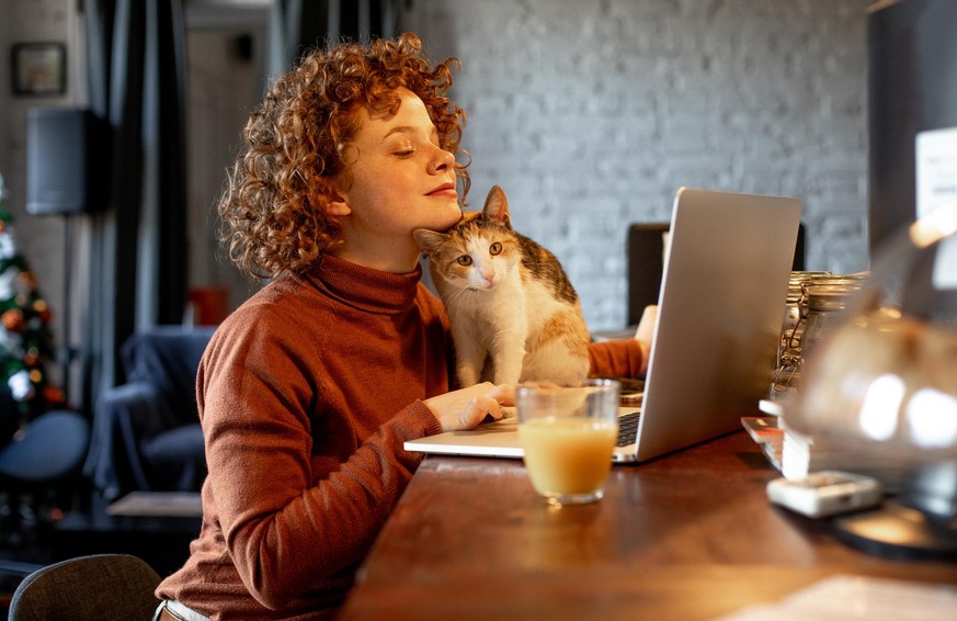 Young woman with cat using laptop