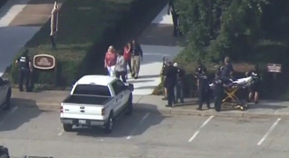 Police evacuate people from a building as a stretcher stands by in this still image taken from video following a shooting incident at the municipal center in Virginia Beach, Virginia, U.S. May 31, 201 ...