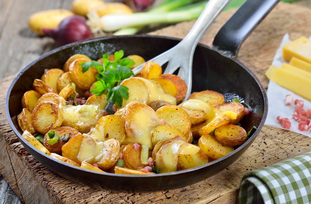 Fried unpeeled baby potatoes with melted mountain cheese and bacon cubes