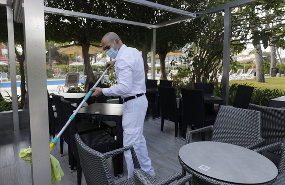 Ein Arbeiter reinigt die Terrasse des Hotels Riu Festival in Palma de Mallorca. Deutsche Reiseveranstalter hoffen, dass sie Urlauber ab den Osterferien wieder nach Mallorca bringen können.