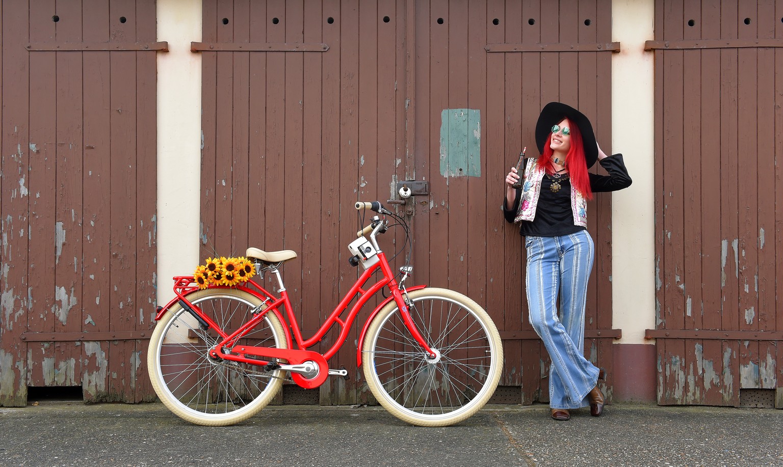 A young girl poses for the camera dressed as a hippie.