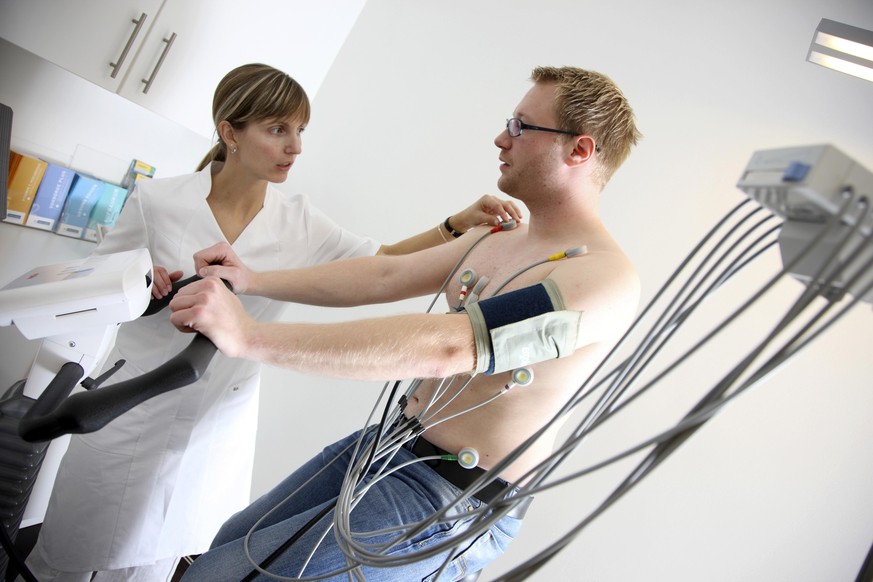 Arztpraxis, Belastungs-EKG, Untersuchung zur Messung der Herzfunktionen bei einem Patienten auf einem Cardiogerät || Modellfreigabe vorhanden