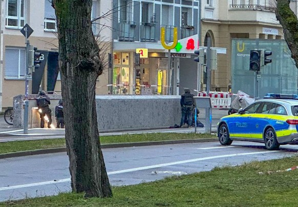 10.03.2023, Baden-Württemberg, Karlsruhe: Polizisten in Spezialausrüstung sind vor eine Apotheke im Einsatz. Die Polizei ist wegen einer Geiselnahme in einem Großeinsatz. In einer Apotheke seien eine  ...