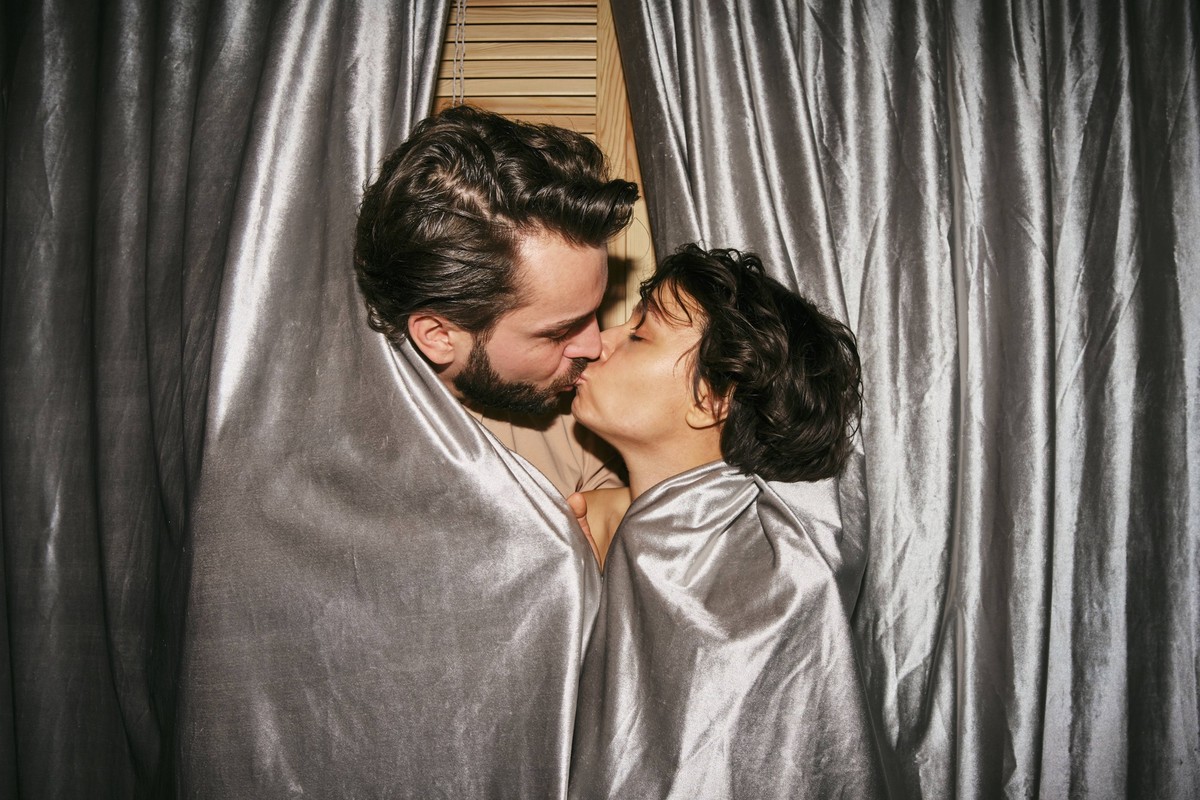 Funny couple kissing behind a curtain at home model released, Symbolfoto property released, MRPF00106