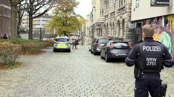 18.11.2022, Nordrhein-Westfalen, Essen: Einsatzkräfte der Polizei stehen am Rabbinerhaus bei der Alten Synagoge. Am Rabbinerhaus bei der Alten Synagoge in Essen sind Einschusslöcher gefunden worden. E ...