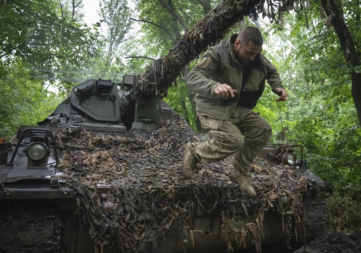 A Ukrainian soldier jumping off the German self-propelled Panzerhaubitze 2000 artillery at his position at the frontline near Bakhmut, Donetsk region, Ukraine, Saturday, May 27, 2023. (AP Photo/Efrem  ...