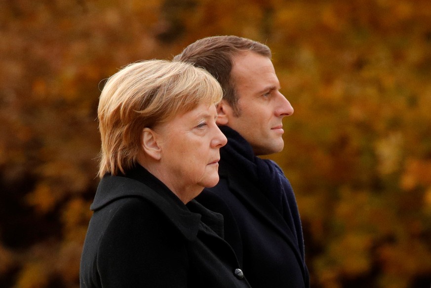 French President Emmanuel Macron and German Chancellor Angela Merkel stand together in the Clairiere of Rethondes during a commemoration ceremony for Armistice Day, 100 years after the end of the Firs ...