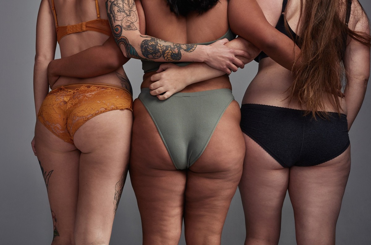 Shot of three young women posing in their underwear against a grey background