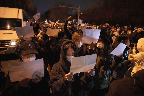 dpatopbilder - 27.11.2022, China, Peking: Demonstranten halten leere Papiere hoch, während sie protestieren. In China hat die strenge Corona-Politik am Wochenende zu den größten Protesten seit Jahrzeh ...