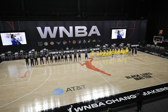 Members of the New York Liberty, left, and Seattle Storm observe a moment of silence in honor of Breonna Taylor before a WNBA basketball game, Saturday, July 25, 2020, in Ellenton, Fla. (AP Photo/Phel ...
