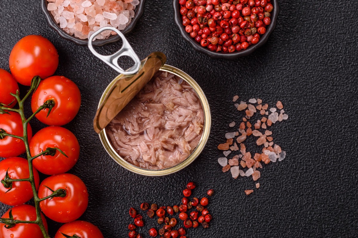 Thunfisch, Fischkonserven in einer Dose und auf einem Teller für die Zubereitung von Sandwiches und anderen Speisen. Thunfisch in Dosen Thunfisch, Fischkonserven in einer Dose und auf einem Teller für ...