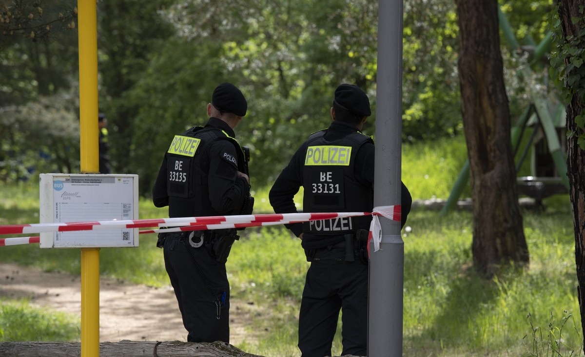 16.05.2023, Berlin: Polizeibeamte stehen an einer Grünanlage in Berlin-Gatow. In unmittelbarer Nähe wurde in den Mittagsstunden ein Mann von einem bislang Unbekannten erschossen. Der Tatverdächtige be ...