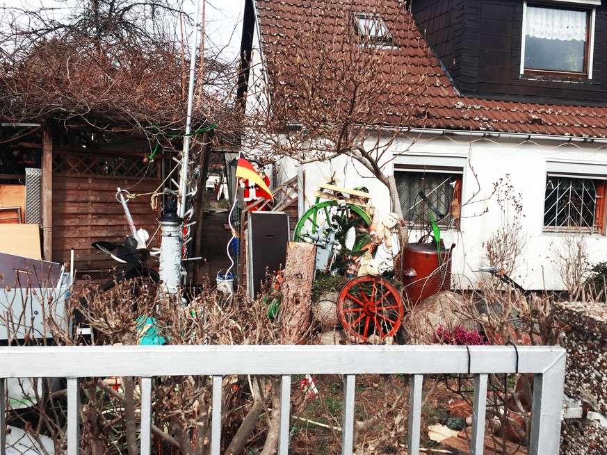 Mitten im März versteckt sich eine Weihnachtsmann-Figur hinter einer Deutschlandflagge.