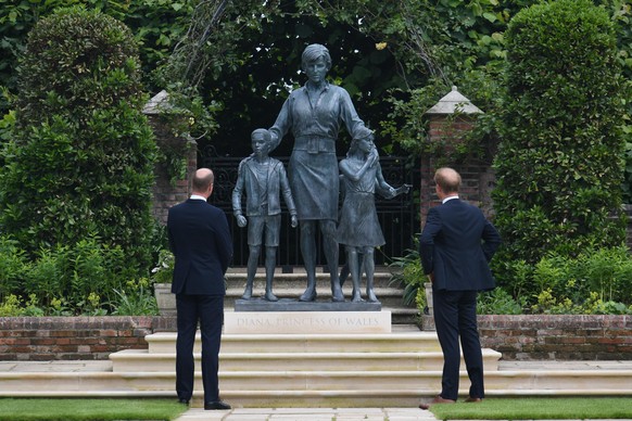 01.07.2021, Großbritannien, London: Der britische Prinz William (l), Herzog von Cambridge, und der britische Prinz Harry, Herzog von Sussex, betrachten eine von ihnen in Auftrag gegebene Statue ihrer  ...