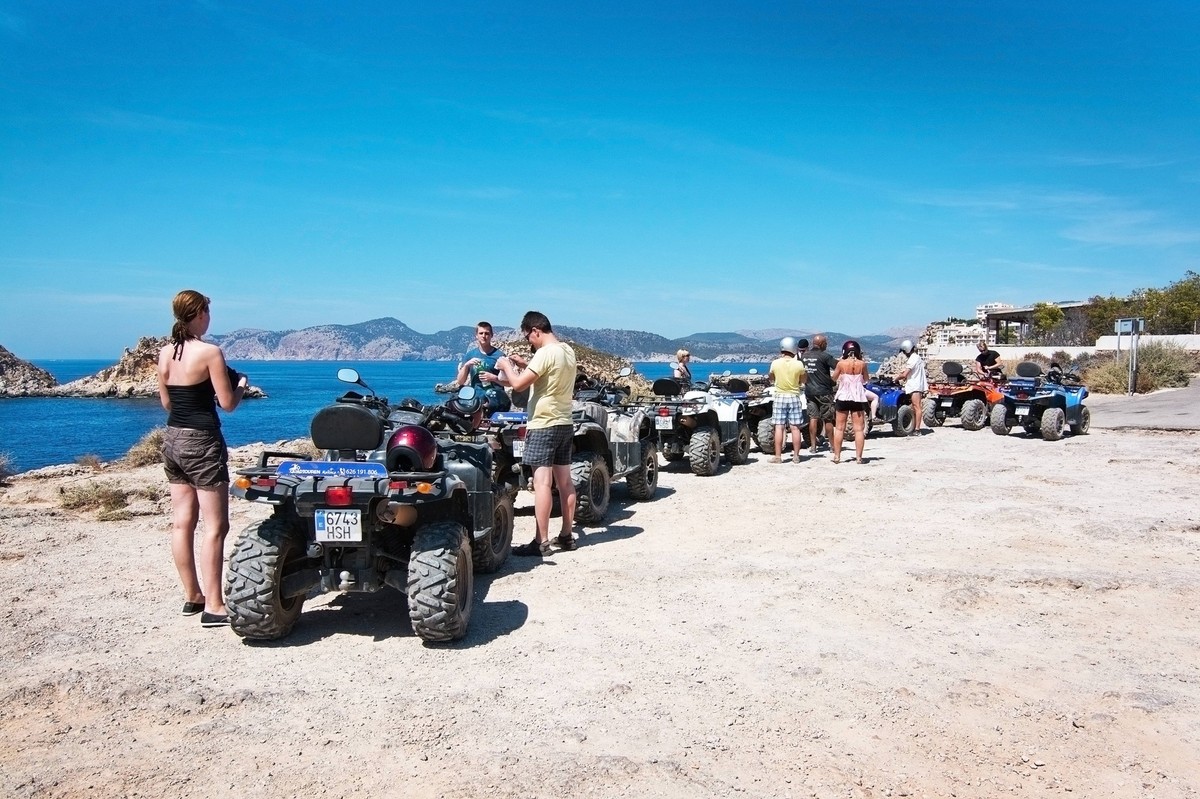 Group on quad cycle tour Mallorca SANTA PONSA, MALLORCA, BALEARIC ISLANDS, SPAIN - SEPTEMBER 3, 2016: Group on quad tour near islets of Malgrats on a sunny summer day on September 3, 2016 in Santa Pon ...