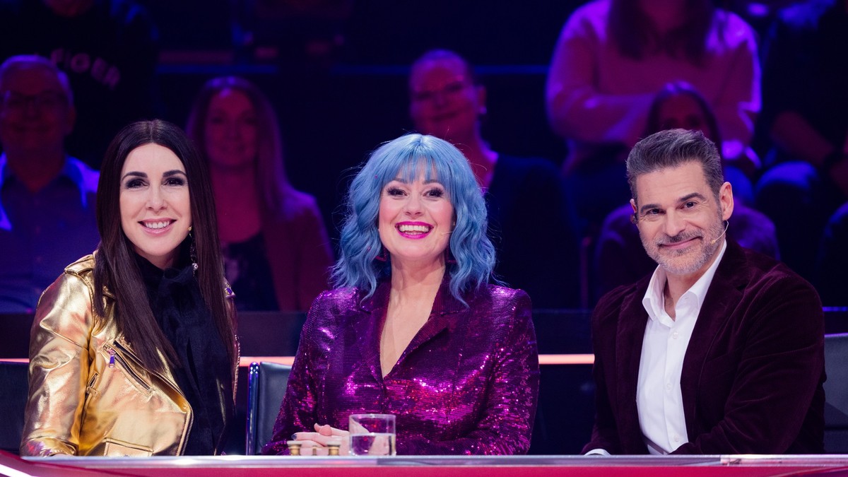 23.12.2023, Nordrhein-Westfalen, K�ln: Ruth Moschner (M), Rick Kavanian (r) und Judith Williams aus dem Rateteam sitzen im Finale der Prosieben-Show &quot;The Masked Singer&quot; am Ratepult. Foto: Ro ...
