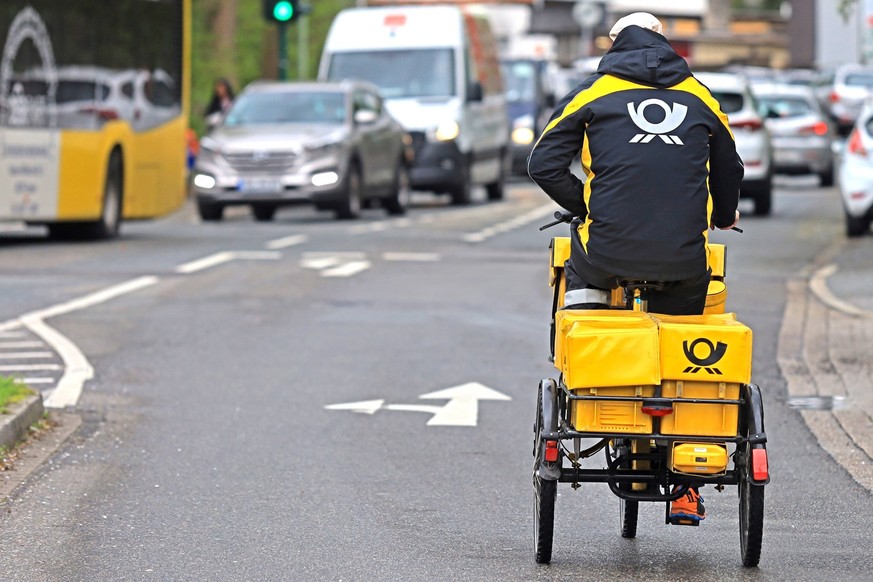 Postzustellung mit dem Fahrrad Ein Postzusteller ist mit seinem Dienstfahrrad in der Stadt Essen unterwegs Essen Nordrhein-Westfalen Deutschland *** Mail delivery by bicycle A mail carrier is on his s ...