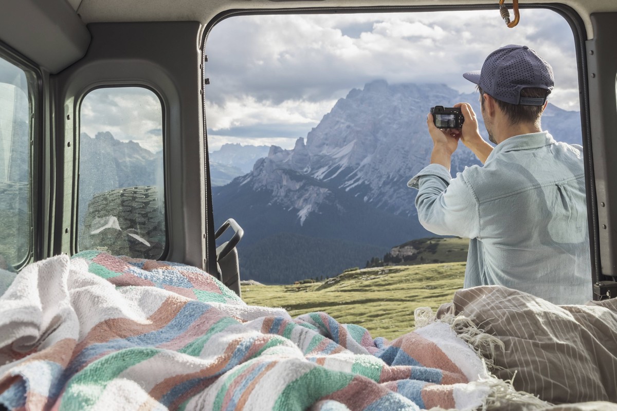 Man photographing scenic mountain ranges while standing by campervan. Sesto Dolomites, Dolomites, Alto Adige, Italy model released Symbolfoto MMAF01403