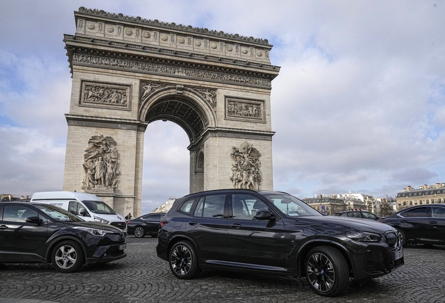 ARCHIV - 31.01.2024, Frankreich, Paris: Ein Sport Utility Vehicles (SUV) fährt auf dem Avenue Champs Elysees, in der Nähe des Arc de Triomphe. Seit Jahren kämpft die Pariser Stadtverwaltung für eine V ...