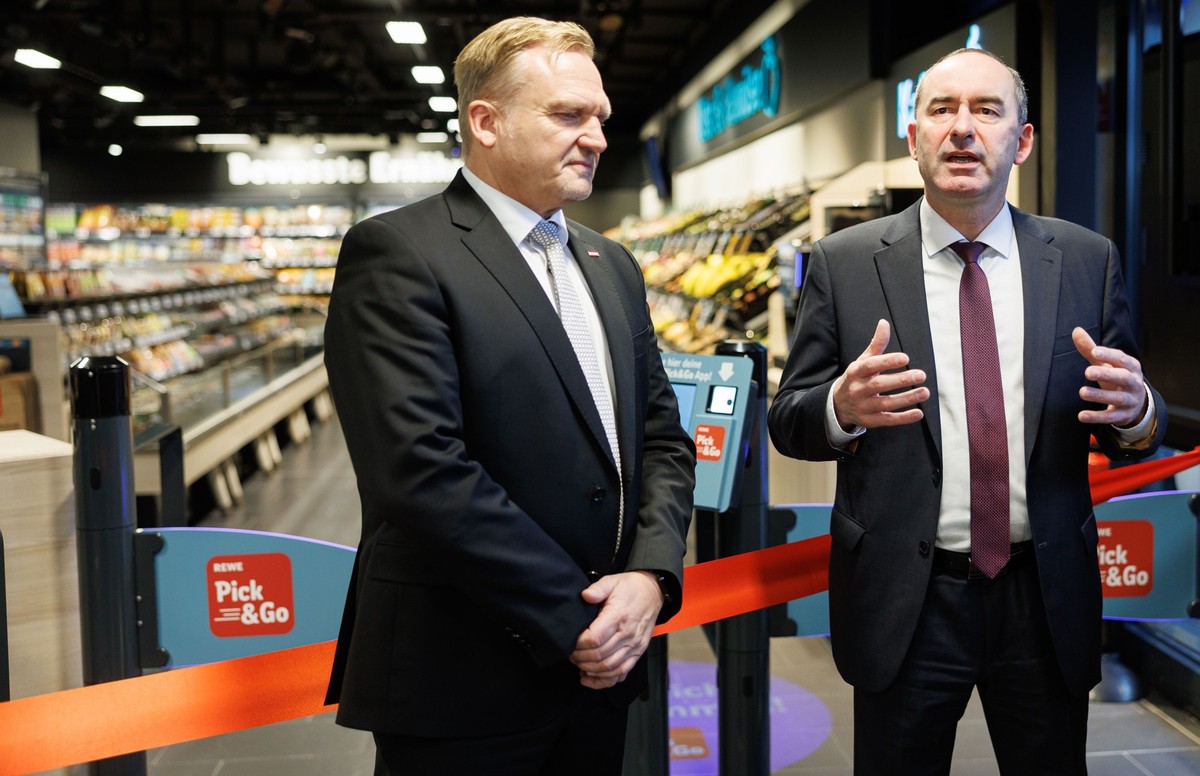 14.12.2022, Bayern, München: Der Bayerische Wirtschaftsminister Hubert Aiwanger (Freie Wähler, r) spricht neben dem Geschäftsführer der Rewe Markt GmbH, Peter Maly, bei der Eröffnung der ersten vollau ...
