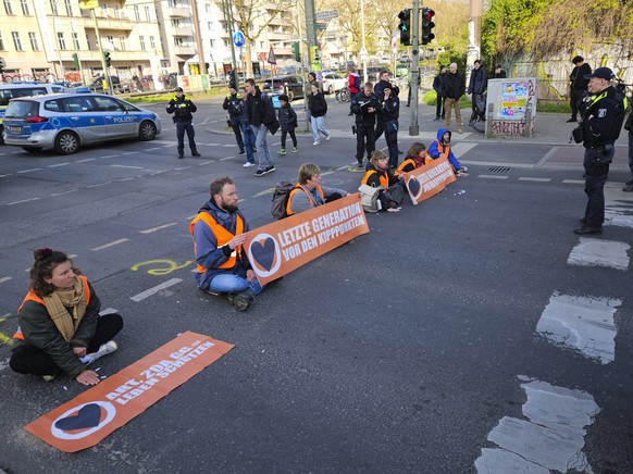 Climate activist Theodor Schnarr, second left, blocks a road with other activists during a climate protest in Berlin, Germany, Friday, April 28, 2023. Climate activists staged a tenth straight day of  ...
