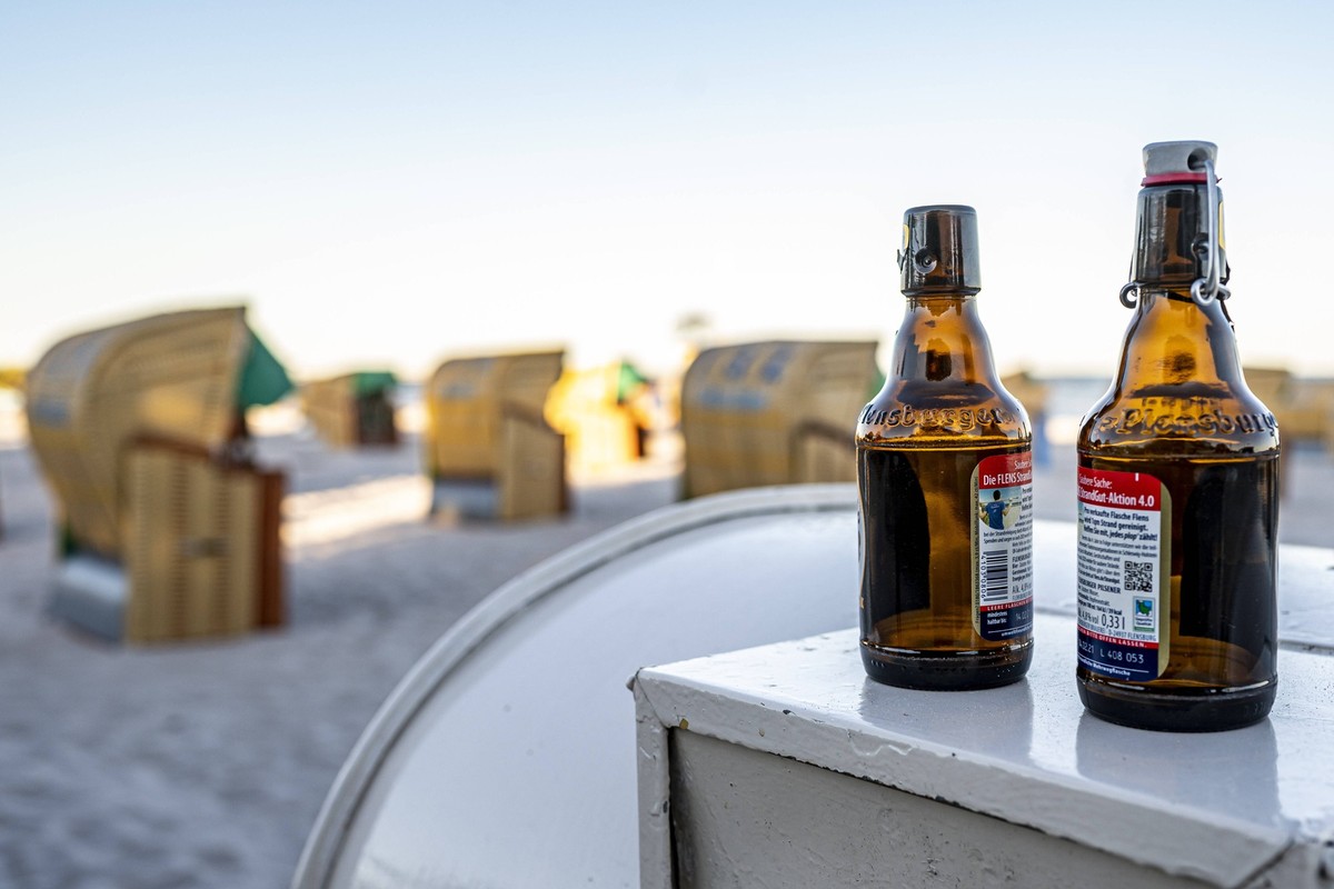 Strand von Grömitz Wirtschaft: Urlaub, Ostsee. Zwei leere Bierflaschen stehen am Rand des Strandes von Grömitz. Das Bundesland Schleswig-Holstein empfängt in der Corona-Pandemie die ersten Urlauber. G ...