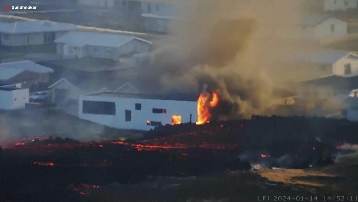 This photo provided by LIVEFROMICELAND.IS shows lava from an erupting volcano in Iceland consuming a building near the town of Grindavik, Iceland, Sunday Jan. 14, 2024. A volcano erupted in southweste ...