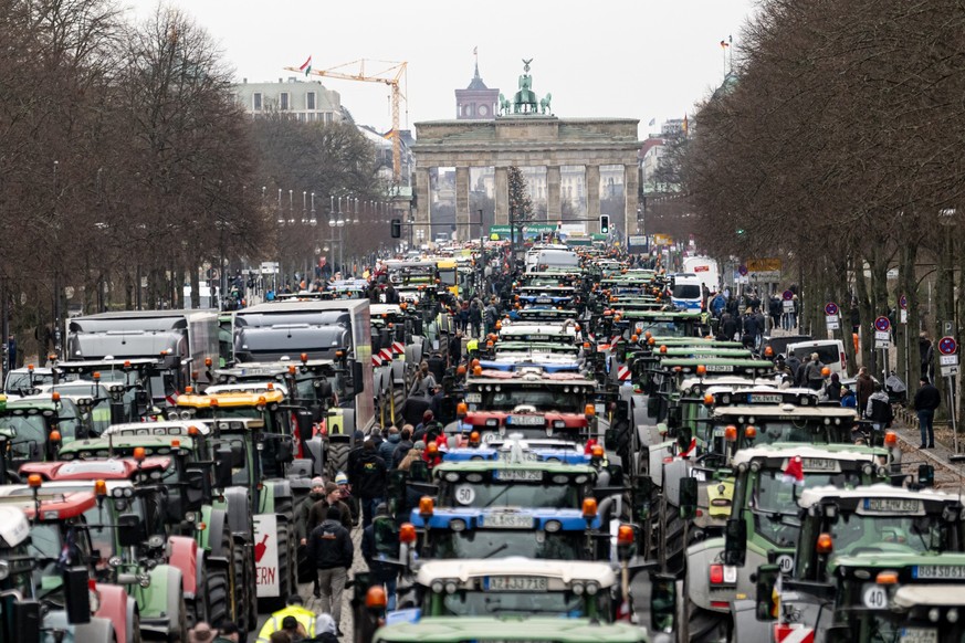 ARCHIV - 18.12.2023, Berlin: Landwirte nehmen mit Traktoren an einer Demonstration des Deutschen Bauernverbandes unter dem Motto «Zu viel ist zu viel! Jetzt ist Schluss!» vor dem Brandenburger Tor tei ...
