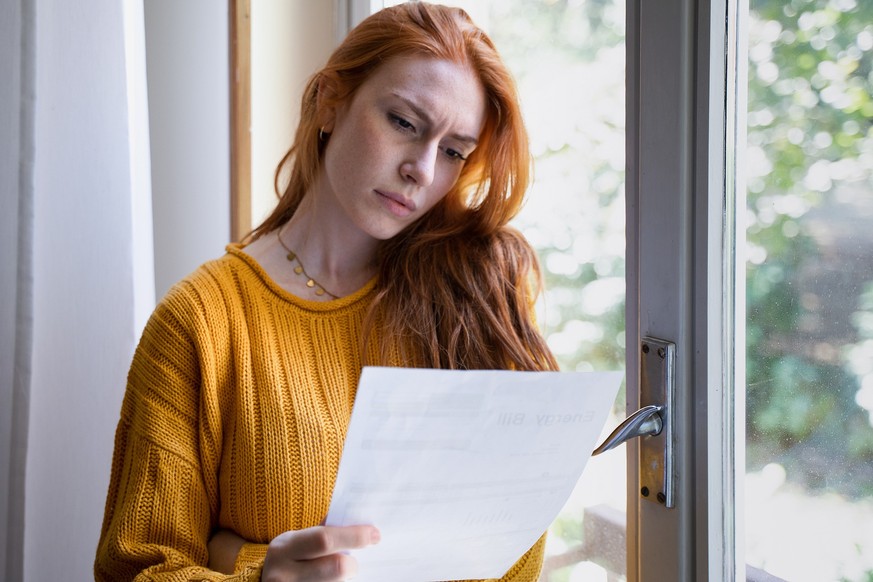Worried woman reading bad news notification at home
