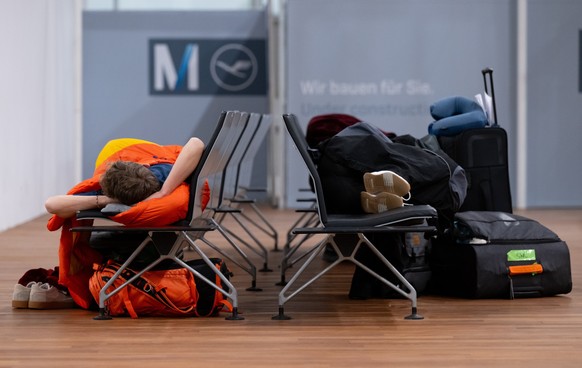 07.02.2024, Bayern, M�nchen: Passagiere schlafen am Flughafen M�nchen auf B�nken am Terminal 2. Die Gewerkschaft Verdi hat das Bodenpersonal der Lufthansa zu einem ganzt�gigen Warnstreik an mehreren F ...