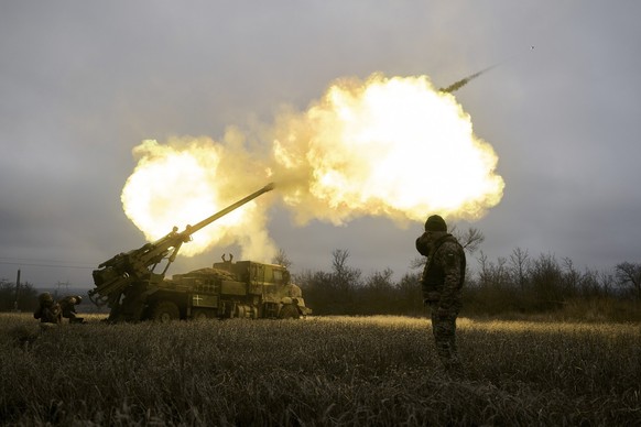 ARCHIV - 26.12.2022, Ukraine, Awdijiwka: Ukrainische Soldaten feuern eine Haubitze auf russische Stellungen. Die Ukraine leidet massiv unter Munitionsmangel für Artillerie. Nun soll Kiew neue Munition ...