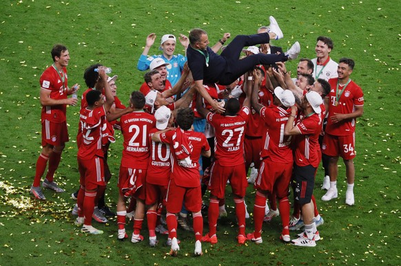 Bayern Munich&#039;s players celebrate their head coach Hansi Flick after winning the German DFB Cup final soccer match between Bayer Leverkusen and Bayern Munich in Berlin, Germany, Saturday, July 4, ...