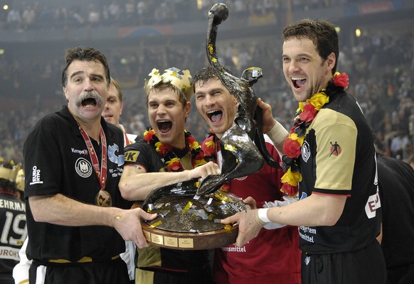 Heiner Brand und seine Spieler Michael Kraus, Henning Fritz und Markus Baur mit der WM-Trophäe 2007. 