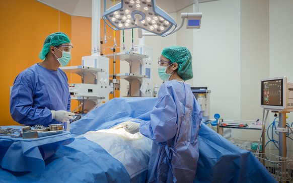 Doctor And Nurse Suture Patient In Emergency Room