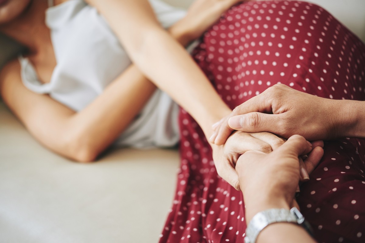 Man holding hand of his sick wife to support her