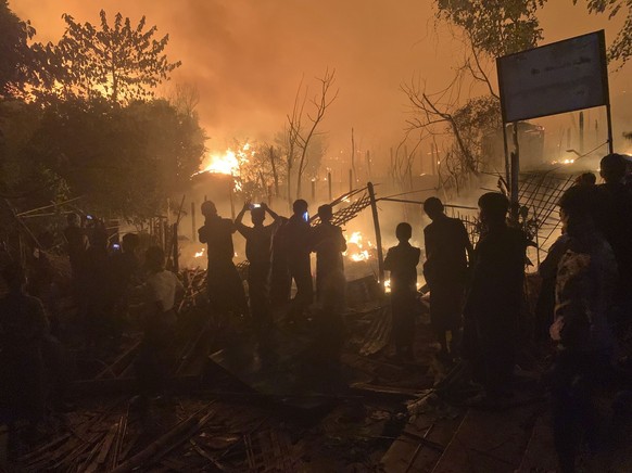 07.01.2024, Bangladesch, Cox&#039;s Bazar: Menschen beobachten, wie Flammen aus einem Feuer in einem Rohingya-Flüchtlingslager in Kutupalong im Bezirk Cox&#039;s Bazar aufsteigen. Foto: Shafiqur Rahma ...