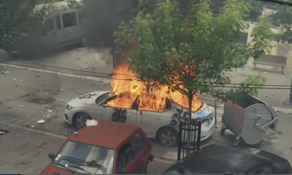 In this grab taken from video, a view of a car set on fire as KFOR soldiers clash with Kosovo Serbs in the town of Zvecan, northern Kosovo, Monday, May 29, 2023. Ethnic Serbs in northern Kosovo have c ...