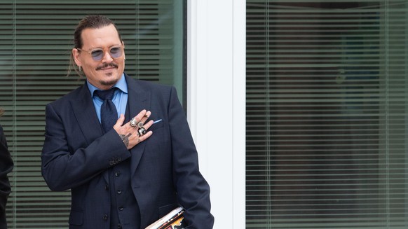 Johnny Depp gestures to fans during a recess in his civil trial with Amber Heard, at the Fairfax County Courthouse, in Fairfax, Friday, May 27, 2022. Depp brought a defamation lawsuit against his form ...