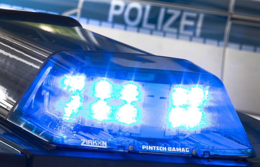 ARCHIV - 27.07.2015, ---: Eine Blaulicht leuchtet auf dem Dach eines Polizeiwagens. Im Hintergrund steht ein weiterer Streifenwagen. (Symbolbild zu dpa: «Mann schießt mit Armbrust - Polizei untersucht ...