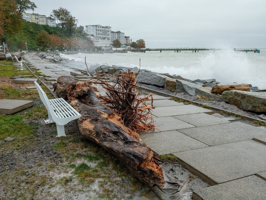 21.10.2023, Mecklenburg-Vorpommern, Sassnitz: Gehwegplatten und Treibholz liegen nach dem Sturm in der Nacht auf der Strandpromenade. Eine schwere Sturmflut hat an der Ostseeküste für zum Teil große S ...