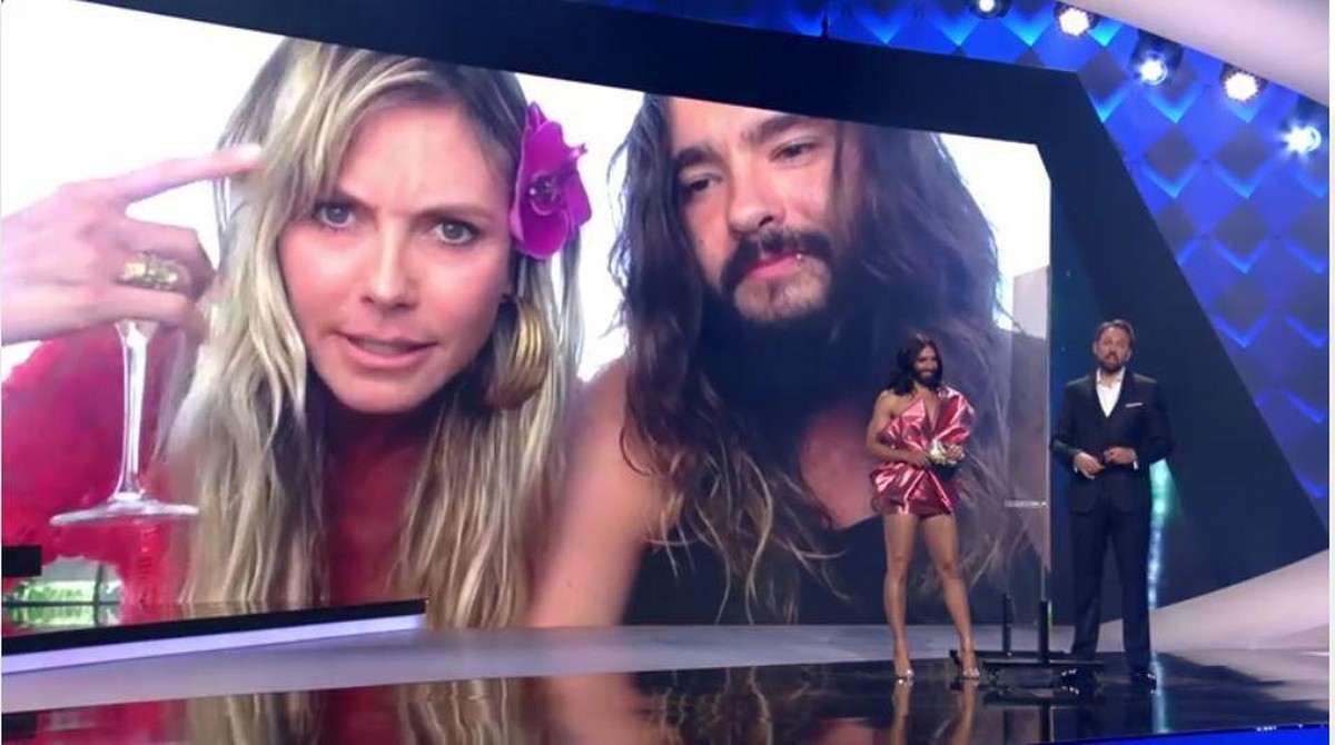 Heidi Klum zeigt dem Moderator den Vogel.