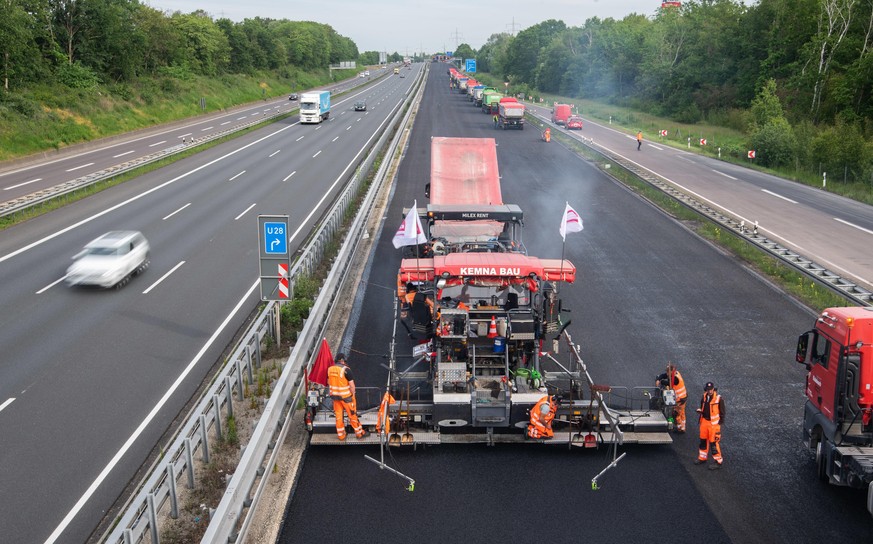 22.05.2020, Niedersachsen, Hannover: Bauarbeiter asphaltieren die Autobahn A2. Die Bauarbeiten auf der Autobahn 2 bei Hannover, die diesmal nur 88 Stunden statt mehrere Wochen dauern sollen, verlaufen ...