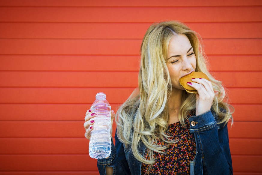 Young woman enjoying a juicy burguer