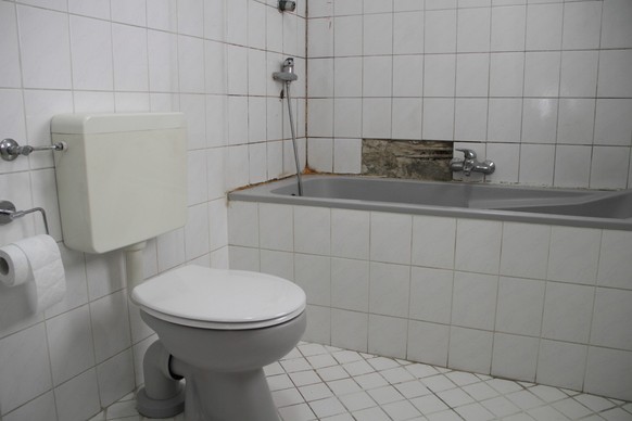 an old bathroom with broken white tiles