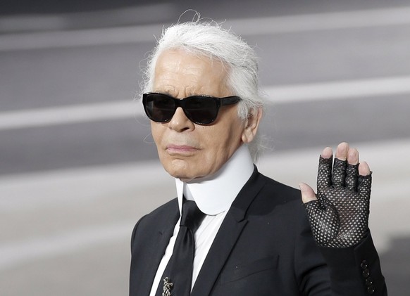 ARCHIV - 05.03.2013, Frankreich, Paris: Karl Lagerfeld hebt die Hand, als er den Applaus nach der Vorstellung seiner Herbst/Winter 2013-2014 Kollektion f�r Chanel entgegennimmt. Der Modesch�pfer w�re  ...