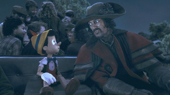 This image released by Disney shows Pinocchio, voiced by Benjamin Evan Ainsworth, left, and The Coachman, voiced by Luke Evans, in Disney&#039;s live-action film &quot;Pinocchio.&quot; (Disney via AP)