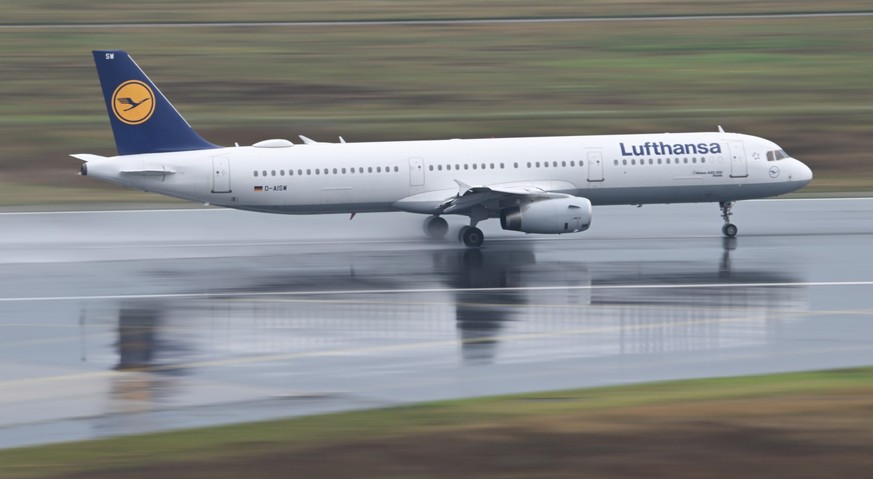 01.08.2024, Hessen, Frankfurt/Main: Ein Airbus 321-200 der Lufthansa startet bei regennasser Startbahn am Frankfurter Flughafen (Aufnahme mit l