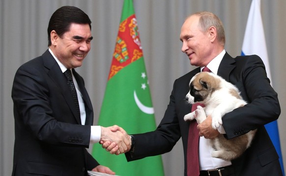 October 11, 2017 - Sochi, Russia - Russian President Vladimir Putin holds a Alabai puppy gifted him by Turkmen President Gurbanguly Berdymukhamedov, left, prior to their meeting in the Bocharov Ruchei ...